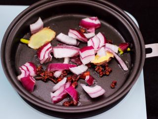 5、番茄牛肉炖土豆,煎锅里倒入花生油烧热后,先小火慢慢炸香花椒和八角,再爆香洋葱。