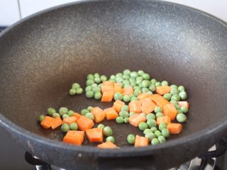 8、鸡丁炒豌豆杏鲍菇,将胡萝卜和豌豆炒至断生，盛出备用。
