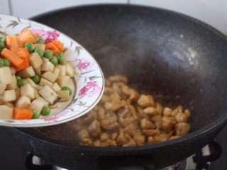 12、鸡丁炒豌豆杏鲍菇,翻炒均匀鸡丁后放入杏鲍菇和胡萝卜、豌豆。