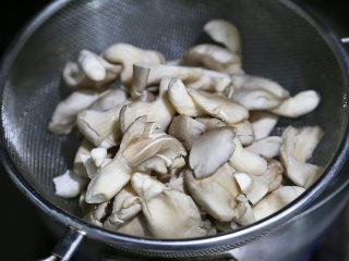 6、双菇炒肉片,将平菇和真姬菇用20cm滤网勺盛起,放入开水中烫30秒