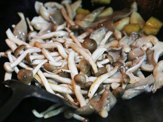 13、双菇炒肉片,将预先处理好的平菇和真姬菇倒入锅内翻炒几下