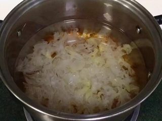 6、牛奶桃胶银耳羹,在锅内放入适量的水,开大火,把洗干净的桃胶和银耳倒入锅内。