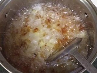 7、牛奶桃胶银耳羹,待锅内沸腾就转中小火熬制20分钟左右。