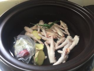 6、肉蟹煲,把鸡爪和料包放入电炖锅中加入适量清水炖煮