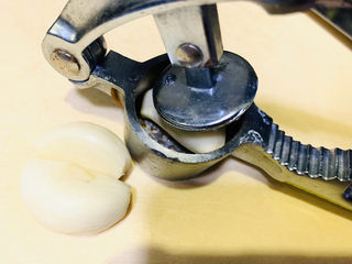 2、蒜蓉小油菜,蒜头洗干净，剥皮，放入压蒜器，一个个用力压；