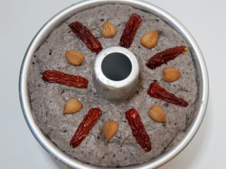 14、黑芝麻发糕,然后在红枣间隔的位置放上一颗杏仁，像图片这样。