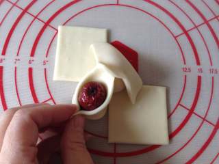 10、枣花糕,再把红枣放在一边的面皮上，并把面皮的两头合过来，尖角捏紧，把红枣包紧