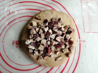 8、红糖红枣馒头,将发酵好的面团取出，放在案板上，使劲揉，揉出面团里面的气体。发酵好的面团若有点粘手，可以撒一层薄薄的面粉在案板上再揉。面团揉了几分钟后，将红枣块倒入