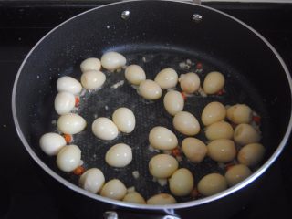 9、照烧金蛋,放入鹌鹑蛋慢慢煸至金黄