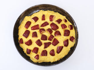 5、南瓜红枣发糕 ,取一个干净的碗，在底部擦上薄薄的橄榄油，放入南瓜糊。红枣对半切开去核，放在南瓜糊上，再裹上一层保鲜膜，静置30分钟，待南瓜糊发酵至2倍大。