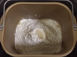 1、红枣枸杞软欧包,除黄油以外的面包材料都放入面包机内（先液体后粉类的顺序），在面粉中间挖个洞，把酵母粉倒入，启动和面程序。