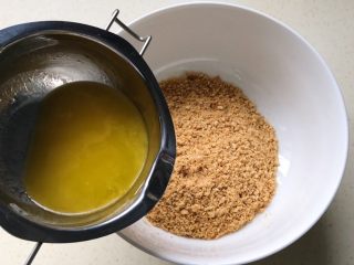 8、奶油红薯蛋糕条,把融化的黄油倒入饼干屑里