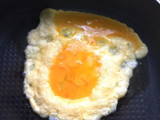 3、野韭菜炒鸡蛋#春意绿#,锅中倒入适量核桃油，烧热后倒入鸡蛋液煎炸片刻。