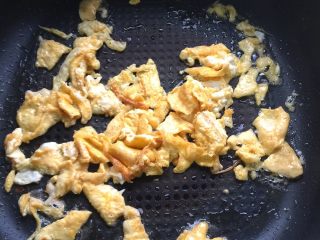 4、野韭菜炒鸡蛋#春意绿#,将鸡蛋用铲子打碎成蛋花片翻炒片刻。