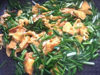 5、野韭菜炒鸡蛋#春意绿#,把野韭菜倒入锅中，与鸡蛋一起翻炒片刻，加入适量食用盐即可出锅。