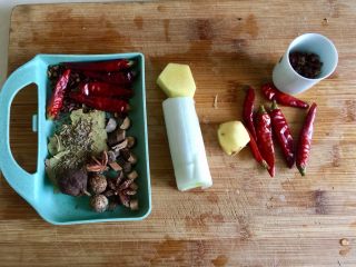 7、来点重口味+麻辣干锅肥肠,等待水开肥肠焯水时，准备煮肥肠的配料。姜一小块，葱白一段，干辣椒五颗，香叶三片，茴香少许，花椒一小把，草果一颗，八角两颗，草寇两个，桂枝少许。右边的姜干辣椒和花椒是后期炒制时需要的