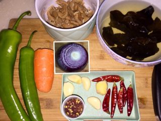 15、来点重口味+麻辣干锅肥肠,干锅肥肠的配菜：煮好的肥肠切段，青椒两根，胡萝卜一小段，泡发好的木耳，洋葱半个（洋葱漏拍了，后面拍了只有拼在一起了），蒜头三颗，姜一小块，花椒适量，干辣椒六颗。