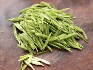 2、香肠辣爆芸豆丝,芸豆摘洗干净后，用刀斜切成丝，小葱切丁。