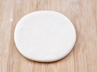 8、老面红枣花样馒头,取一个小面团,用擀面杖擀成圆形面饼,(其它的小面团用保鲜膜盖好)