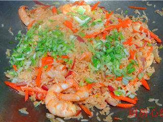 8、海鲜炒饭,倒入蒸好的海鲜米饭翻炒均匀，然后，倒入蒸好的干贝；海米；鲜虾仁。在调入盐；胡椒粉。最后撒入葱花即可出锅。