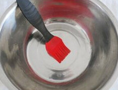 3、玉米蒸糕,在容器内刷一层油，葡萄干和枸杞要提前泡软拭干水分、红枣去核切小块