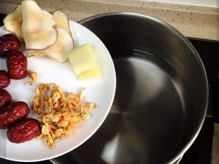 3、红枣山药炖乌骨鸡,炖锅中放入冷水和红枣、海底椰、海螺片、生姜、虫草花后。让鸡块冷水入锅。开大火至煮沸。