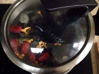 4、红枣山药炖乌骨鸡,煮沸后加入料酒。转小火炖煮1小时。