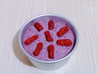 8、好吃不上火~红枣紫薯发糕,取出发酵好的发糕模具,将红枣去核,一切二,摆放在发糕糊上,如图。