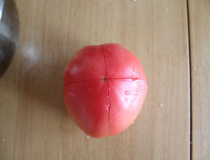 2、动脑筋做让小朋友爱吃的素菜——番茄菜花 ,西红柿用刀在顶部切个十字口,划破表皮即可。