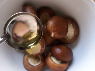 17、#咸味#烤牛肉酿香菇,撒入少许烧烤粉，倒入适量橄榄油拌匀，腌制五分钟至其入味。