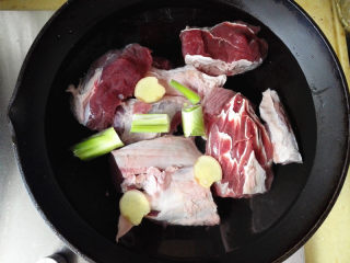 3、咖喱牛肉土豆,锅里添凉水，将牛肉放进去，葱和姜也一起放入锅中，打开火准备焯水去腥去血沫，