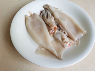 3、鱿鱼炒芹菜,然后把鱿鱼身体表面的黑膜撕掉，冲洗干净后的鱿鱼就变得白白净净了。