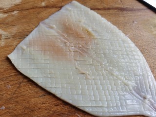 4、鱿鱼炒芹菜,然后换另一个角再开始切，切的深度跟刚才一样，切好后就形成若干菱形的花纹。