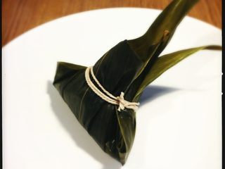 8、端午节 枣粽,用绳子捆住粽子，如果以上步骤进行的顺利，不需要五花大绑，只要缠紧几圈即可。
