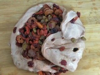 7、红酒果料面包,把果干加入大面团揉到果干均匀附着在大面团（也可以用厨师机或者面包机揉）