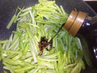 8、补肾健胃~红油烧烤味孜然韭黄,再放入韭黄叶铺在上面倒入两勺生抽，炒拌均匀七成熟，关火