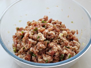 4、猪肉山芹馅蒸饺,顺时针一个方向将肉馅搅拌均匀