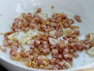 6、鲜虾小白菜豆腐汤,接着放入虾皮和火腿丁翻炒片刻