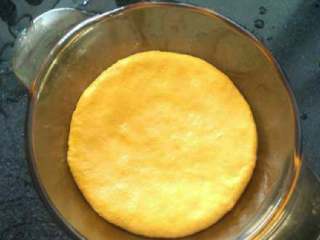 5、南瓜发糕,取一个大碗，刷点油（直接用手抹油，抓面团的时候还可以防粘！），放进面团，压扁压圆。