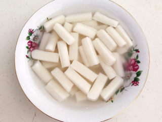 5、鸡蛋炒年糕,把煮好的年糕捞出来放入碗里，加入少许凉开水，免得煮好的年糕粘在一起