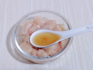 3、简单自制零食 无油版低脂劲爆鸡米花,将鸡块加入器具中，加入料酒！