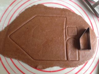 5、圣诞姜饼屋,将面团擀薄,0.3CM的薄面片。用模具将屋子部件一个个印出来,计算好哟,一般同一模具需要印出两个。(最好在案板上铺一张保鲜膜,再放面团,在面团上也盖一张保鲜膜,才擀开。案板不大的话,将面团切小块再擀