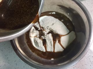 4、蔓越莓红糖发糕,将红糖酵母水倒入面粉中搅拌。