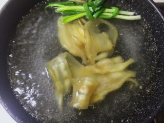 4、瑶柱花胶猪骨汤【附花胶泡发】,锅里注入水，放入生姜，葱结，黄酒。大火煮开。放入花胶煮五分钟。花胶放进热水会缩起来卷曲是正常的。