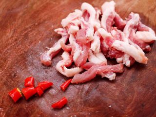 2、芦笋炒肉,把猪肉用刀切成条状，小米辣切成小丁。