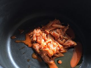 7、酸辣暖胃的 辣白菜豆腐锅,锅内放入油、辣白菜小火翻炒一会