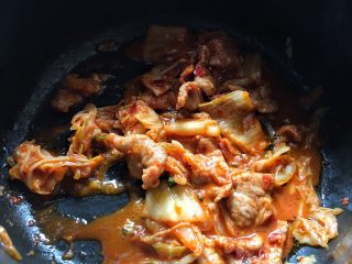 8、酸辣暖胃的 辣白菜豆腐锅,加入腌好的肉片，翻炒一会