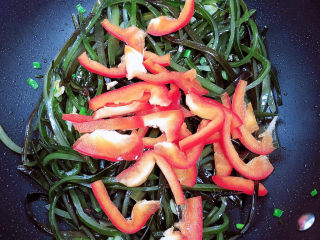 11、香辣海带丝,倒入红椒丝翻炒均匀。