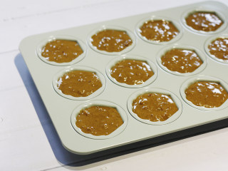 11、贝壳红枣小蛋糕,烤箱预热150度30分钟，用勺子将蛋糕糊放入模具中，烤箱预热结束后将模具送入烤箱。