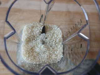 2、蔓越莓米糕,大米倒入破壁机搅拌杯里，盖上杯盖和加料口盖；